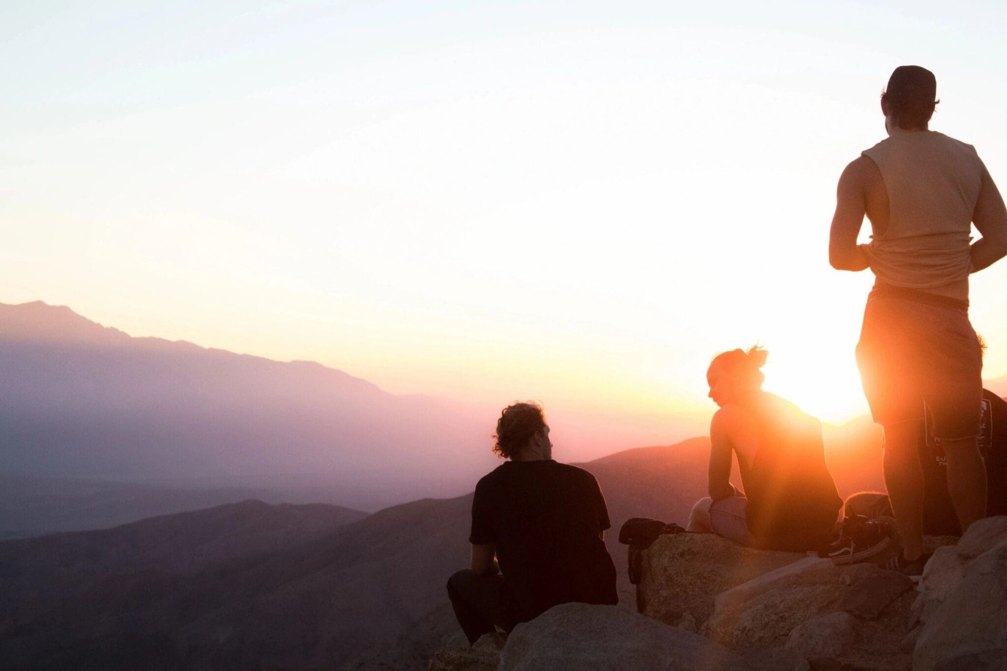 Silhouetted group watching mountain sunset